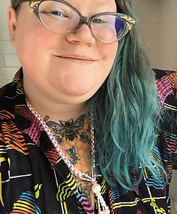 Photo of illustrator Theo Nicole Lorenz, smiling at the camera.